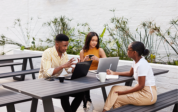 A group of three young professionals are meeting to work collaboratively on a work project